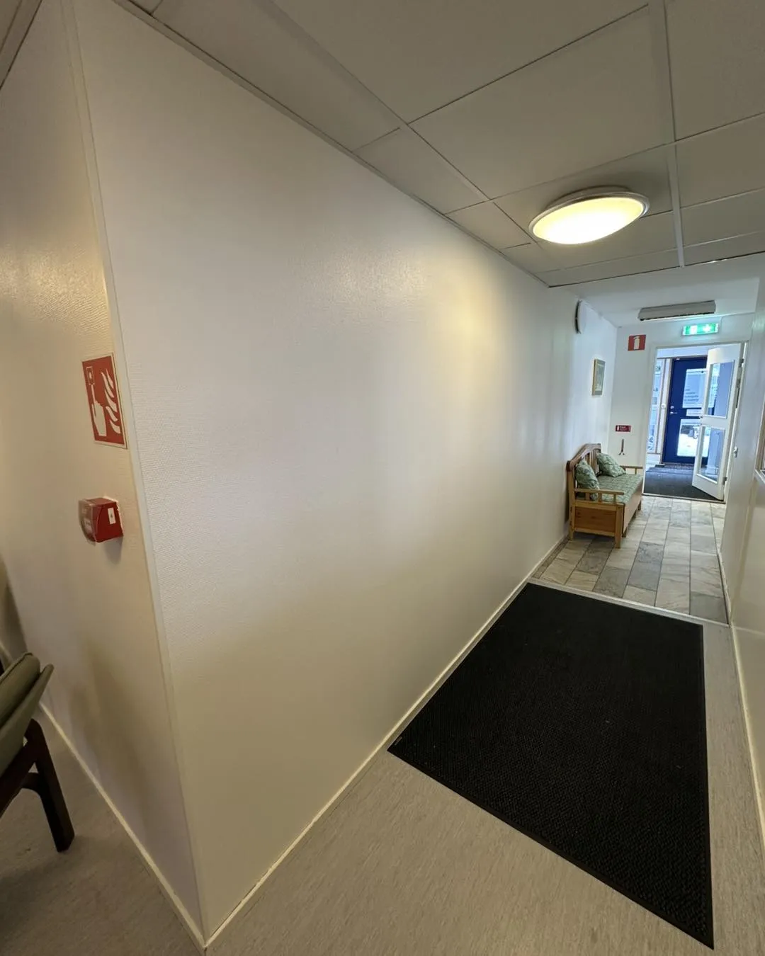 Målare arbetar på höjd med fasadmålning – säkerhet och noggrannhet i varje penseldrag.